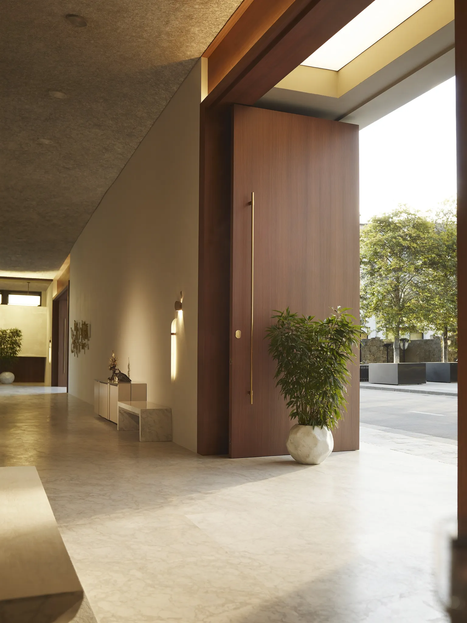 Hall de entrada com porta pivotante em madeira nobre