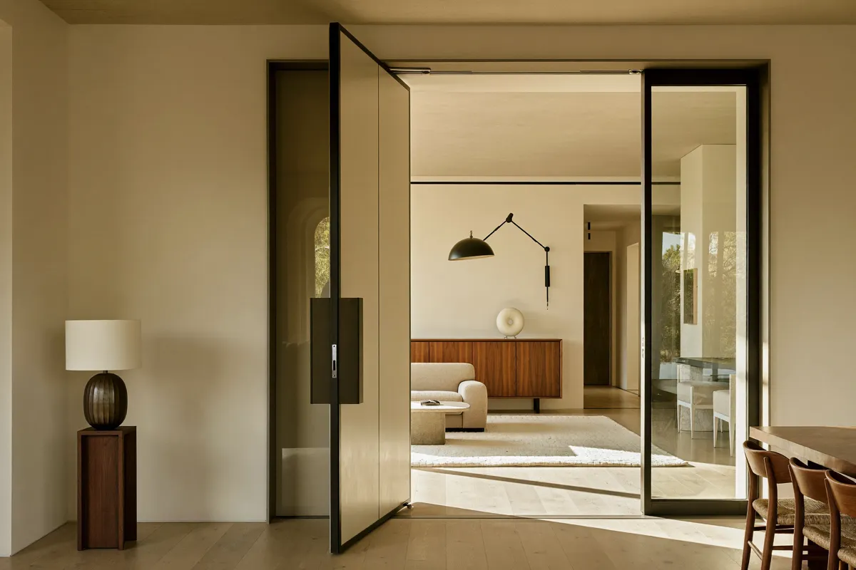 Ambiente residencial contemporâneo com porta pivotante ampla sob medida